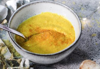 Au dem Foto sieht man eine Schüssel mit gelben, veganen "Käse"-Dip. Darüber ist Kurkuma gestreut. | © SONNENTOR