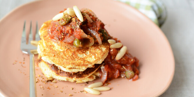 Pikante Pancakes | © SONNENTOR Auf dem Foto sind würzige Pancakes mit Tomaten-Kapern-Ragout darauf zu sehen. | © SONNENTOR