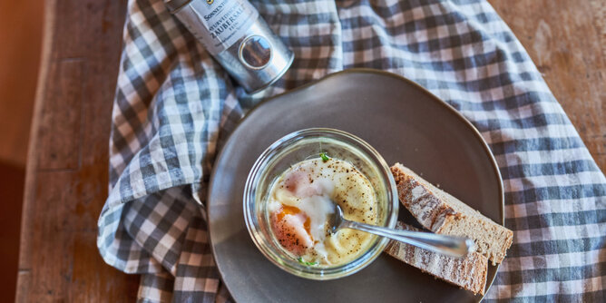Ei im Glas | © SONNENTOR Auf dem Foto sieht man das Frühstück Ei im Glas. Daneben sind zwei Brotscheiben zu sehen. | © SONNENTOR
